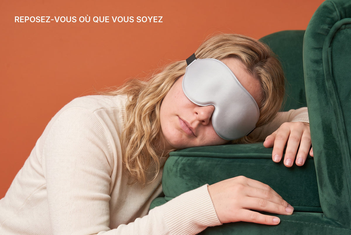 Woman asleep in an armchair with the AerPack 3D Sleep Mask in Grey: rest wherever you are